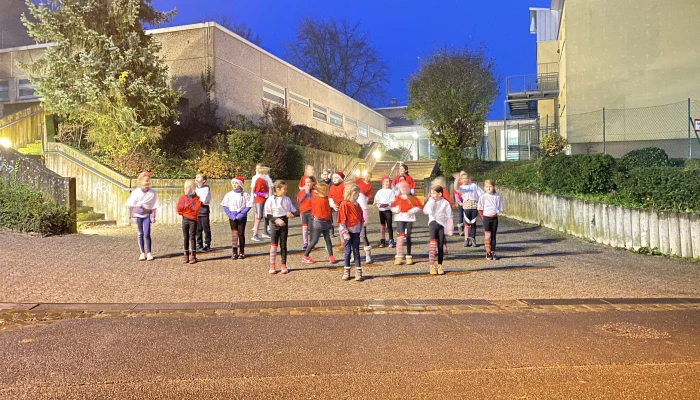 Die Zumba Kinder stehen in drei Reihen hintereinander, bevor gleich der tänzerische Auftritt beginnt